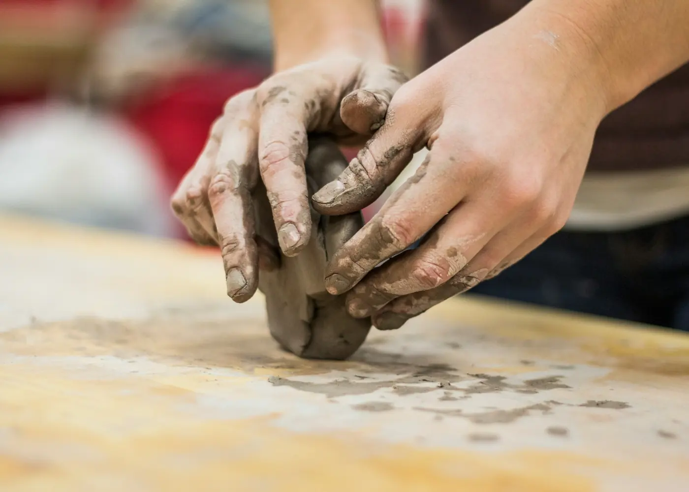 Hands working wet clay