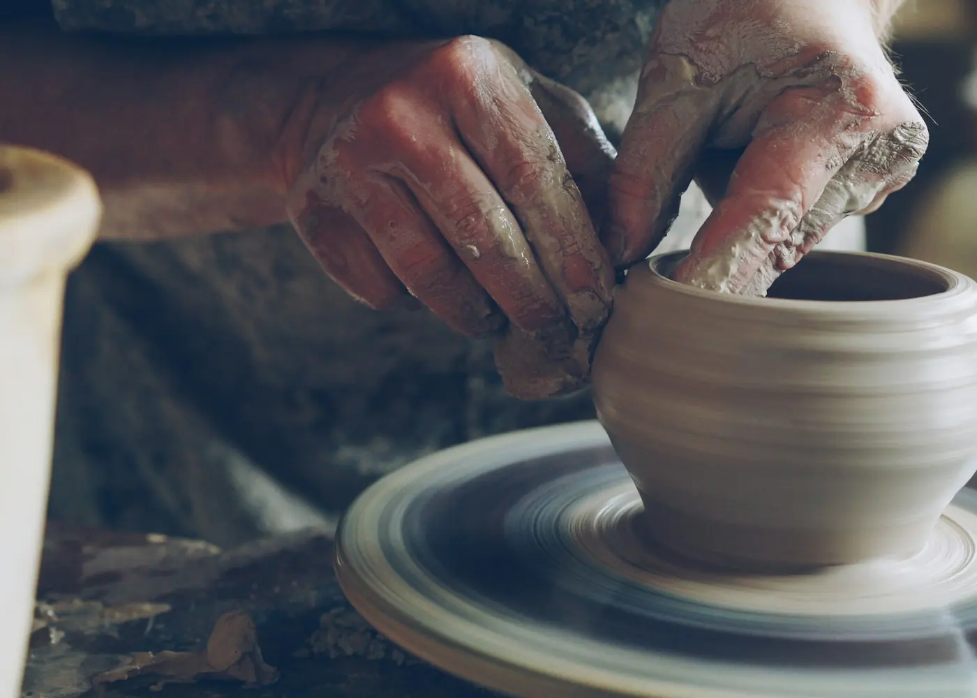 A potter shaping a vessel on a wheel